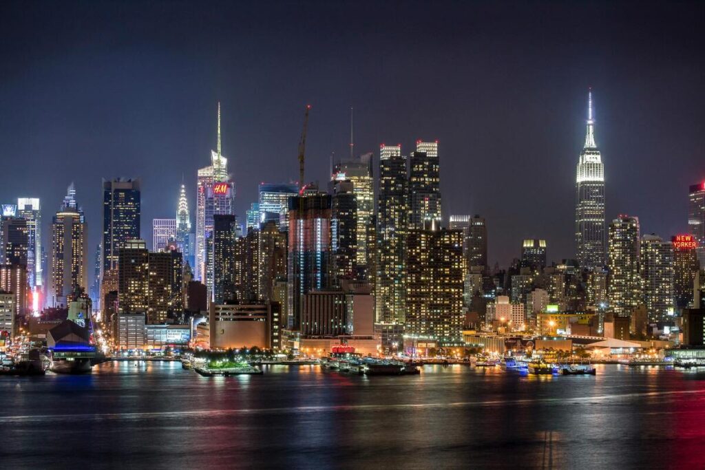 Magnifique photo de nuit de New York, de ses gratte ciels hypnotiques et de ses néons.