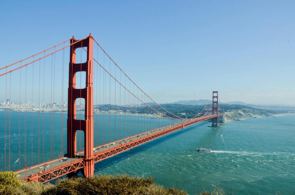 Très jolie photo du golden bridge rouge avec san francisco au loin après la baie